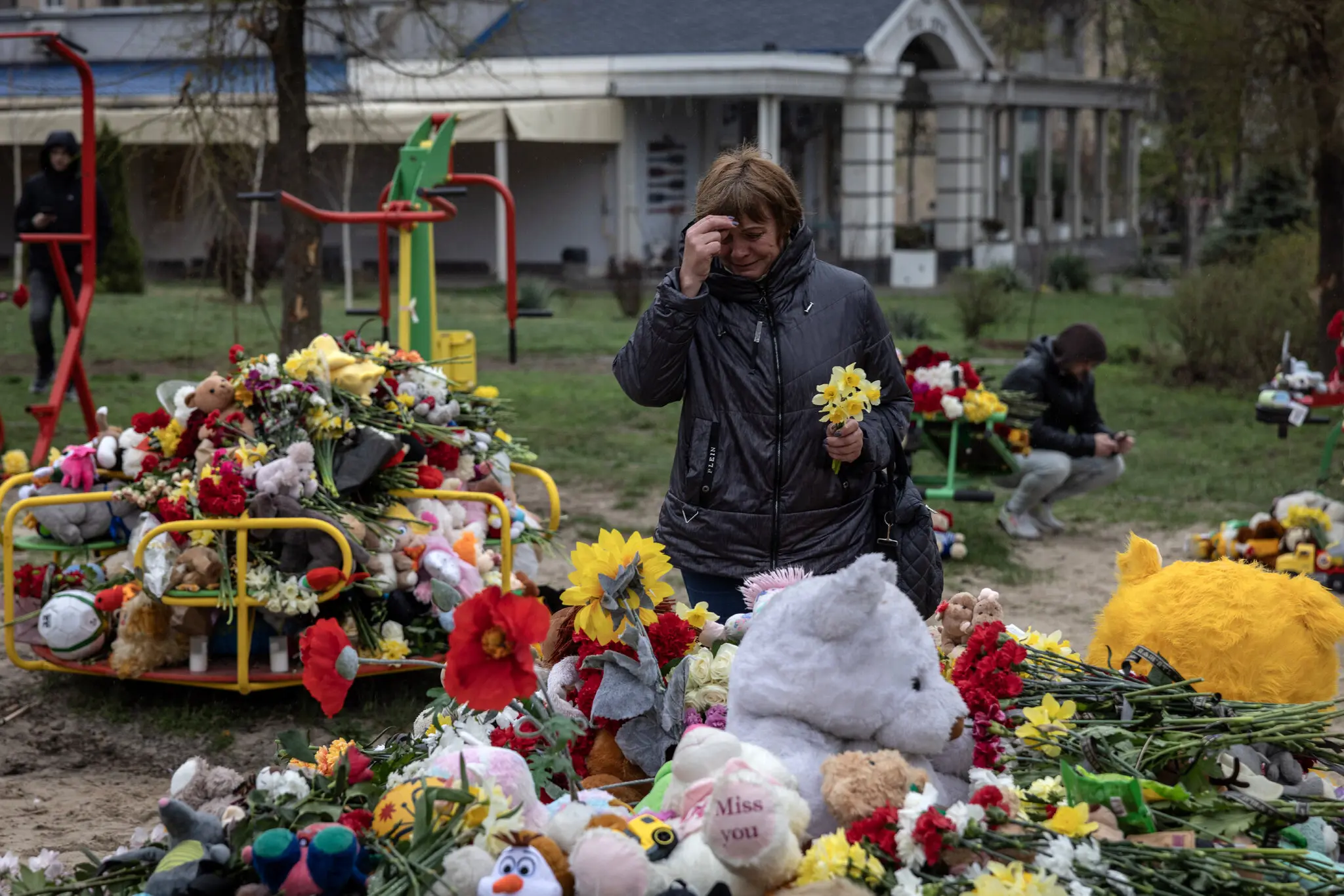 Жінка молиться біля імпровізованого меморіалу в Кривому Розі, Україна, де в п’ятницю російський удар убив 20 людей, у тому числі дев’ятеро дітей.